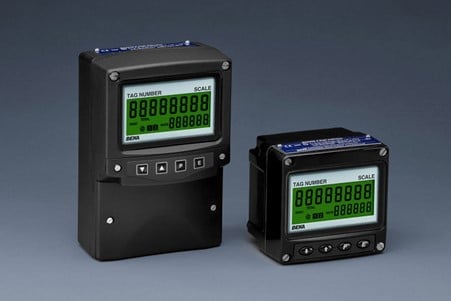 Two black electronic control display units with green digital screens on a gray background.