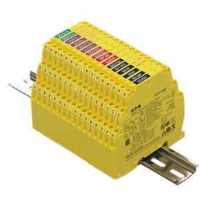 Yellow modular industrial terminal block with numbered ports and colored label tabs, mounted on a metal rail.